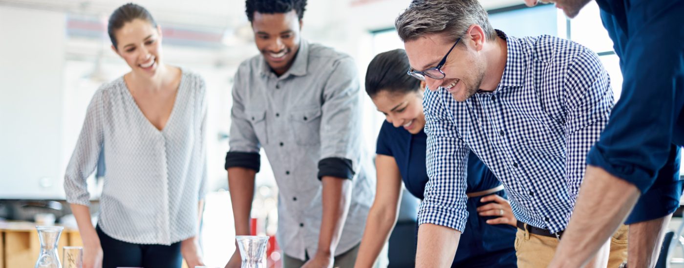 Group of diverse professionals gathered at a table to look at a strategic plan.